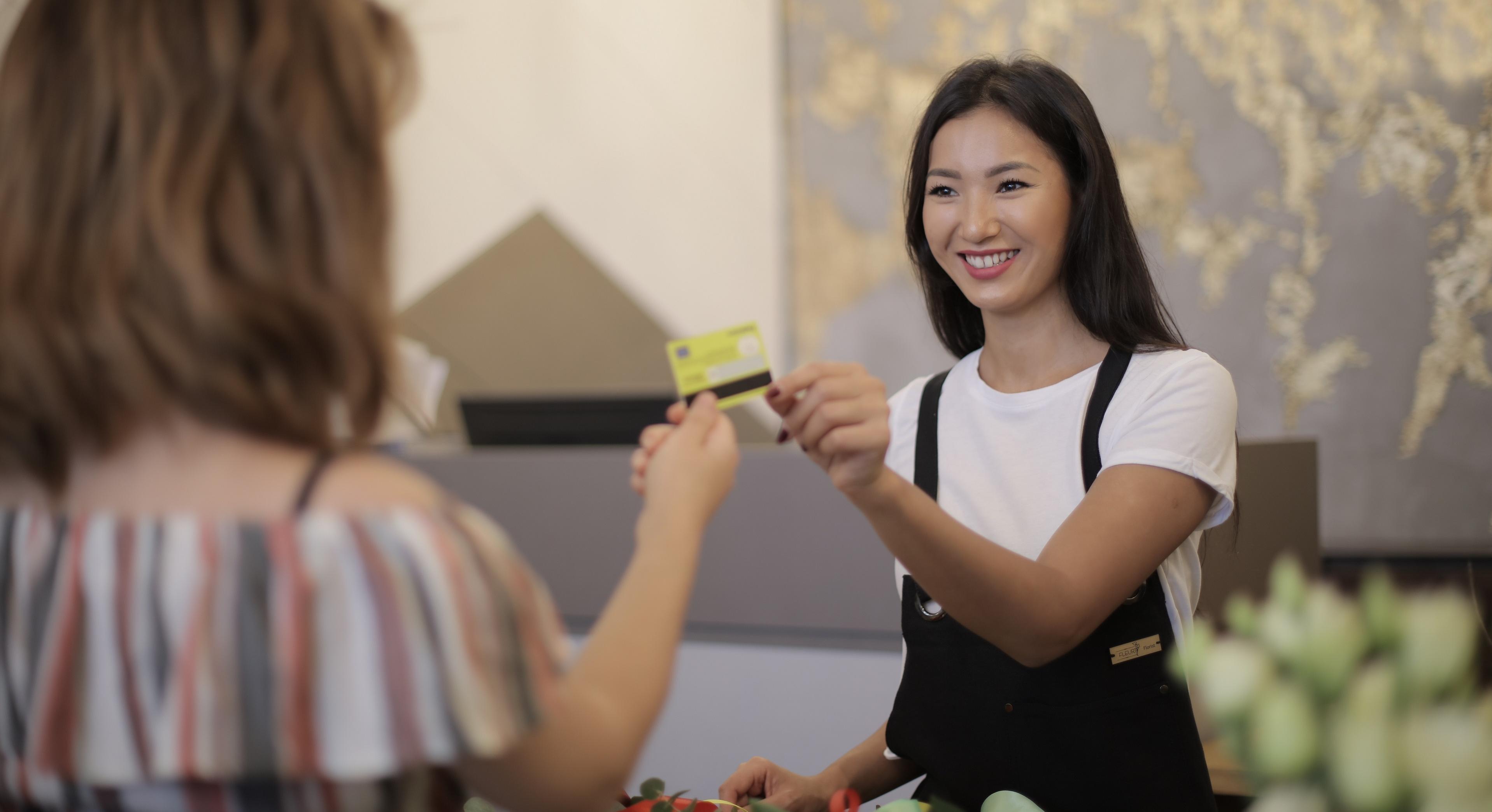 woman handing clerk credit card