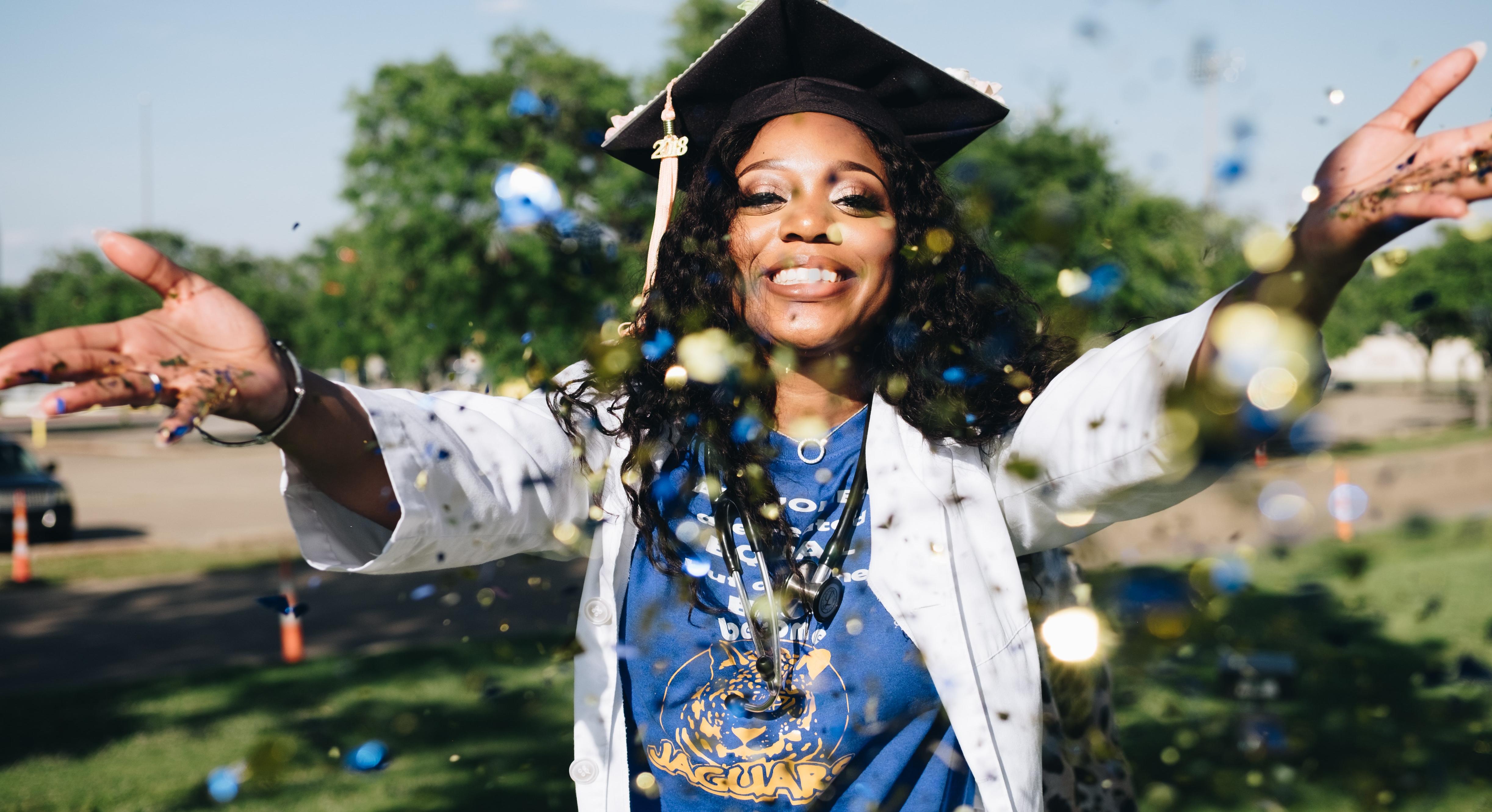 girl in graduation cap throwing confetti
